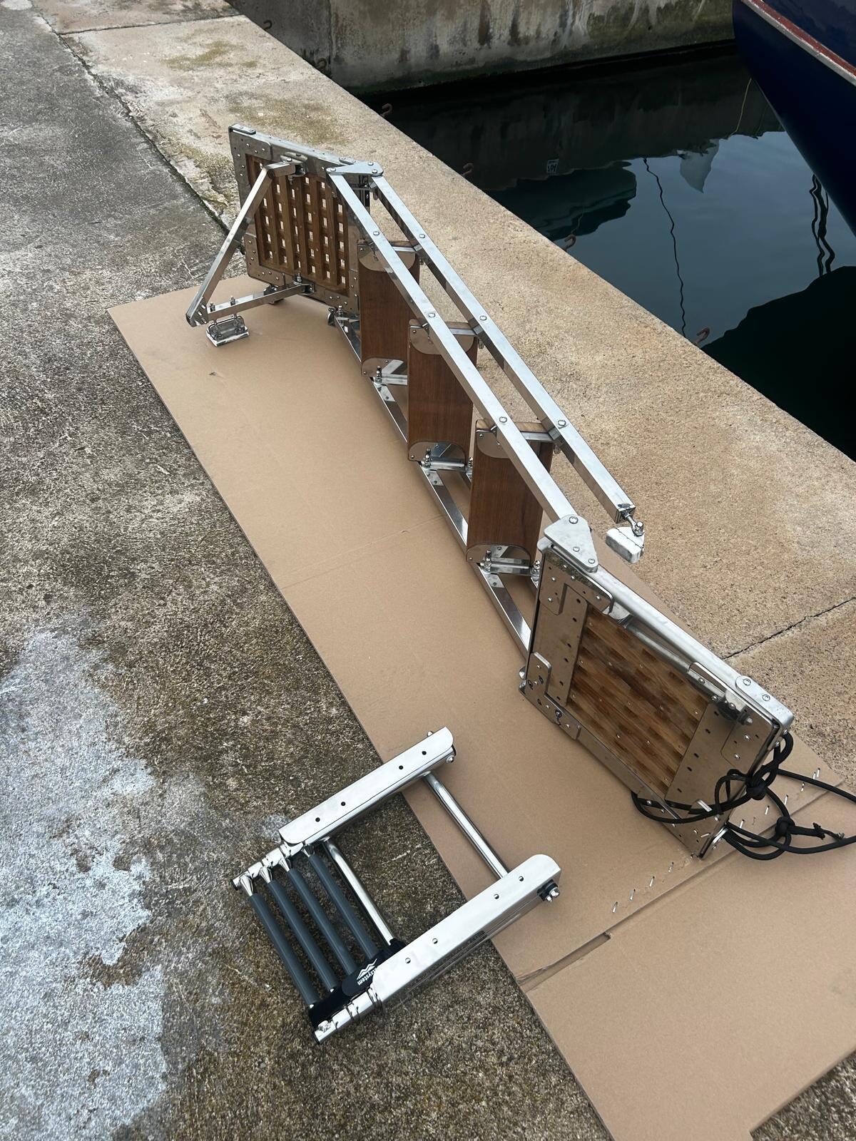 The bespoke stainless and teak boarding ladder aboard Gran Blau, laid out before fitting