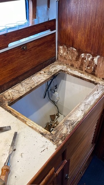 The old countertop cut open, showing the plumbing beneath