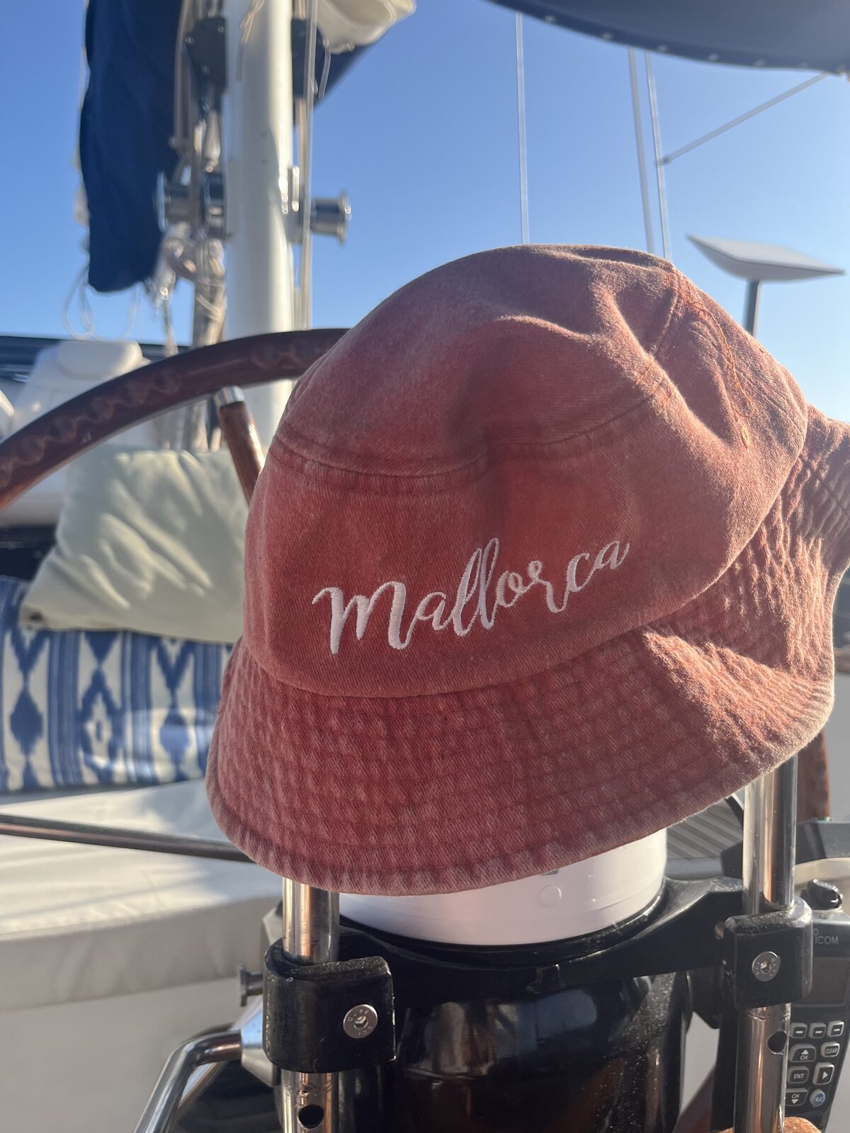 A Mallorca sun hat hanging on the wheel aboard Gran Blau