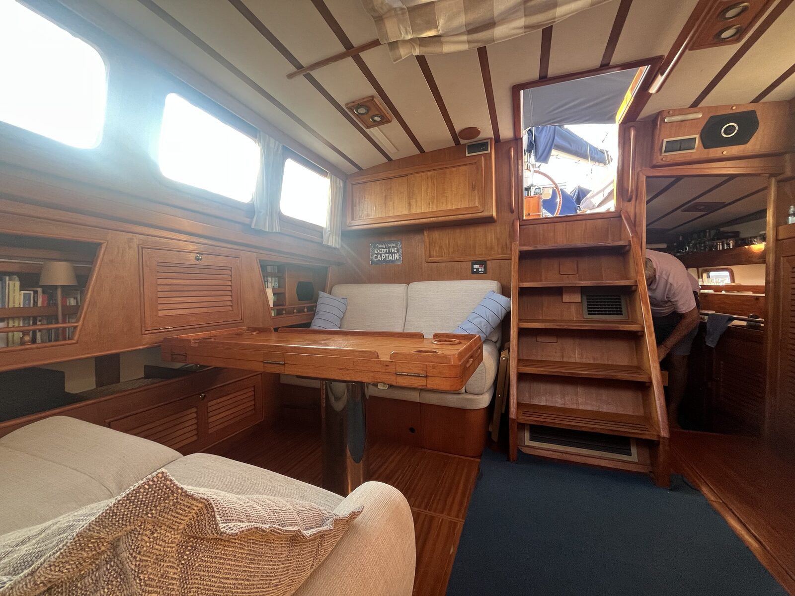 The saloon aboard Gran Blau, with a Nobody's Perfect Except the Captain sign
