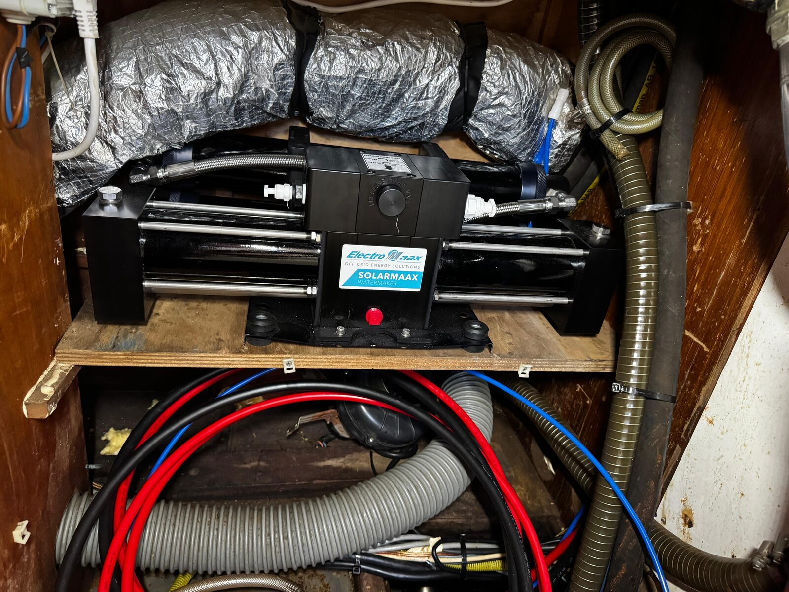 The ElectroMaax SolarMaax Watermaker unit installed aboard Gran Blau, with the Clark Pump cylinder assembly and pressure relief valve visible