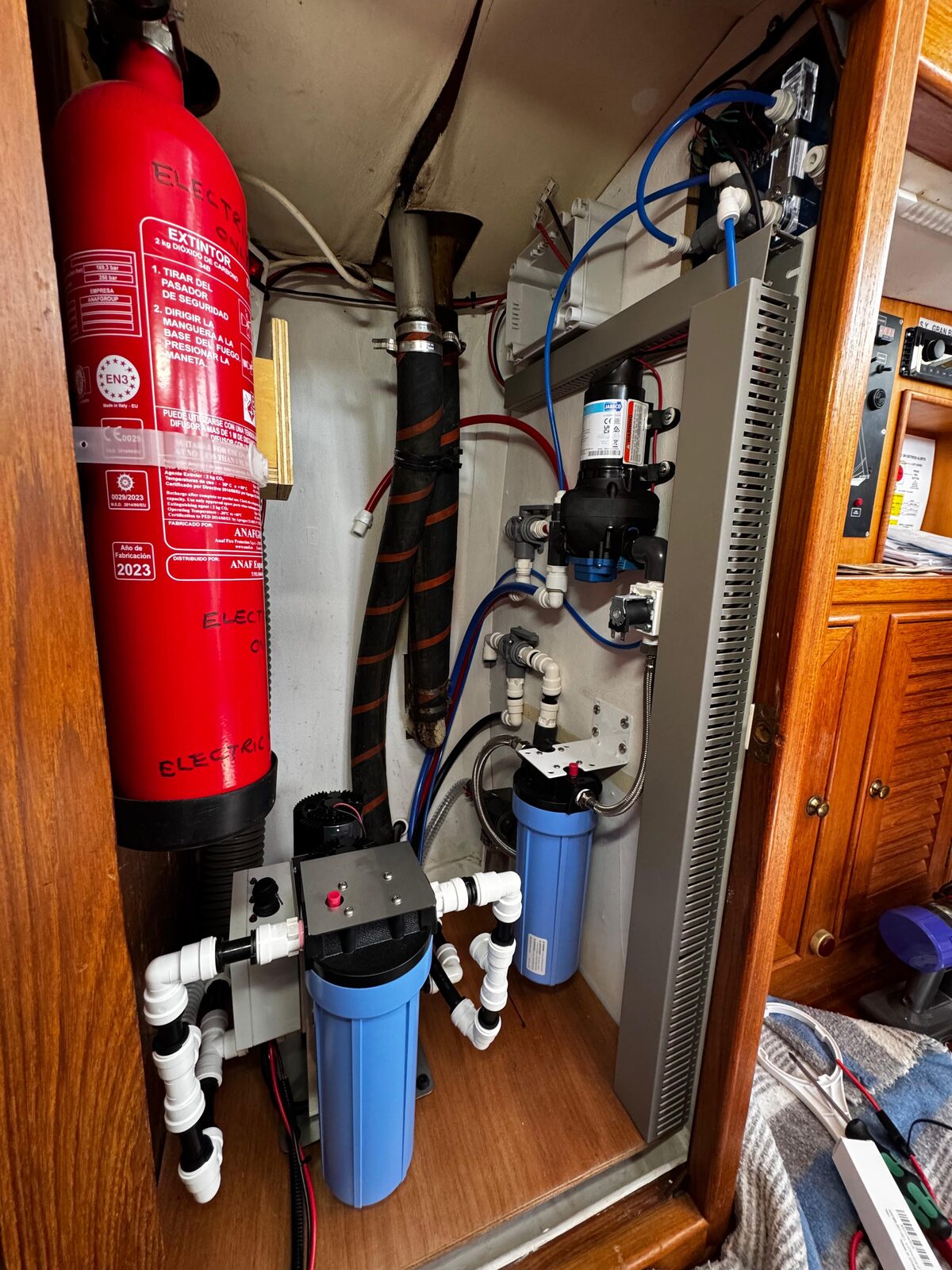 The complete SolarMaax 340 system installed in its locker aboard Gran Blau, alongside the pre-filter and product water filter housings